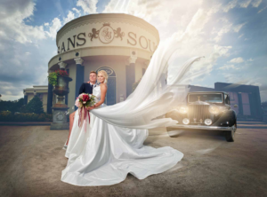 Elegant bride wearing a flowing couture gown outdoors at San Souci, captured in a timeless bridal portrait with soft movement and natural light.